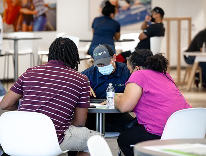 Several EchoPark guests gather inside a light, modern EchoPark store.