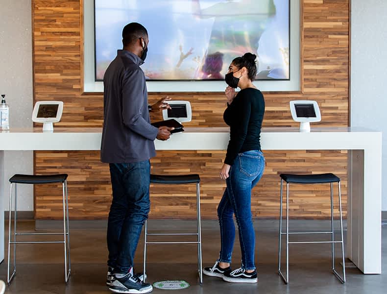 Several EchoPark guests gather inside a light, modern EchoPark store.