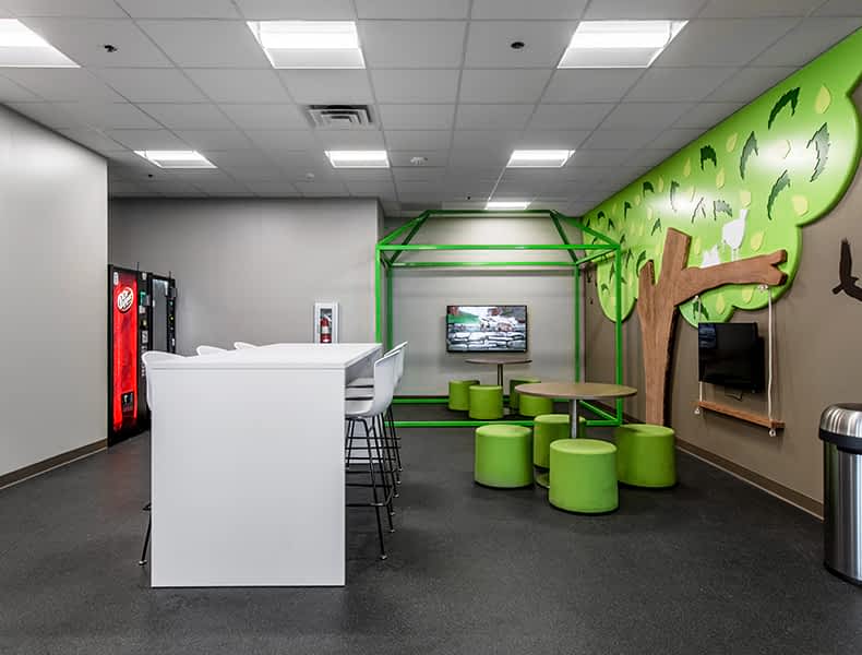 The kids' area of an EchoPark store has colorful blue and green seating and tables, with toy cars on display and children's books to keep the little ones occupied.