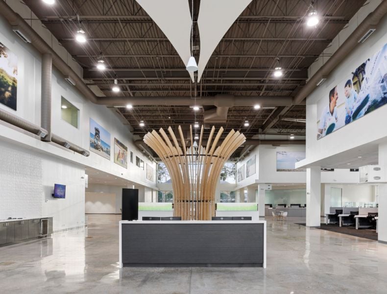 A bright and modern front desk area, featuring an open, spacious design and a striking wooden sculpture.
