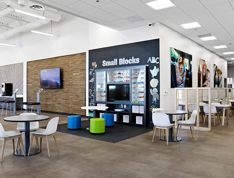The kids' area of an EchoPark store has colorful blue and green seating and tables, with toy cars on display and children's books to keep the little ones occupied.