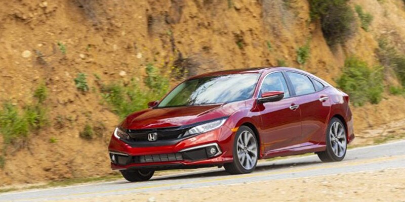 Image shows a red Honda Civic parked on a mountain road.