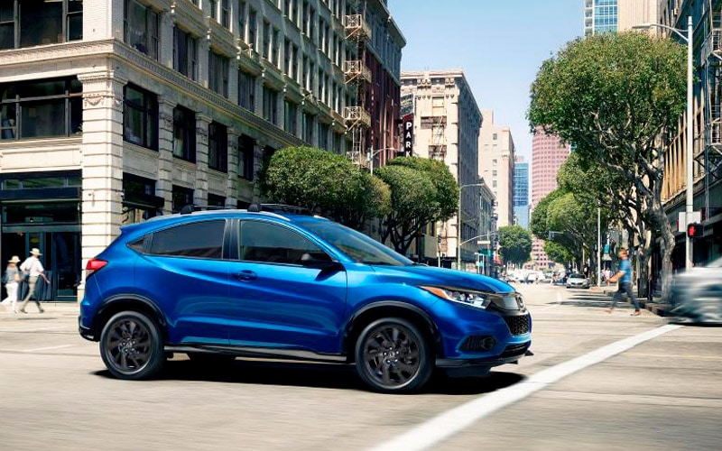 Image shows a blue Honda HR-V driving in a city.