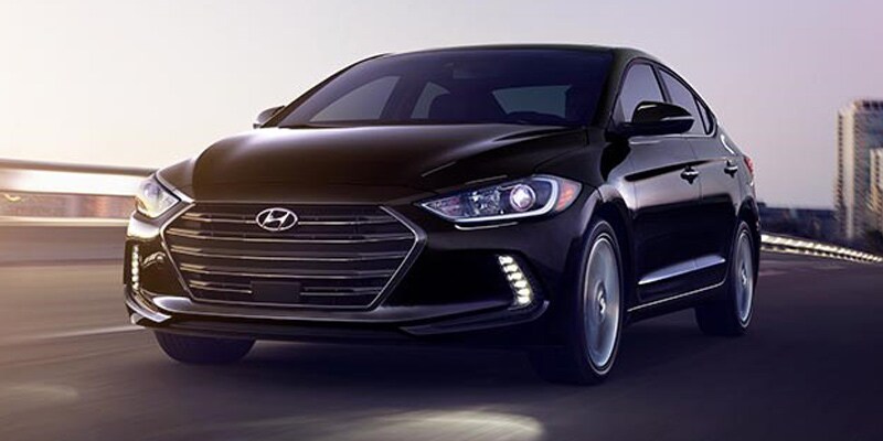 Image shows a black Hyundai Elantra driving across a bridge.