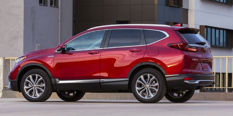 A composite image including a red Mazda CX-5 parked outside a city storefront and a red Honda CR-V parked on concrete in front of city office building.